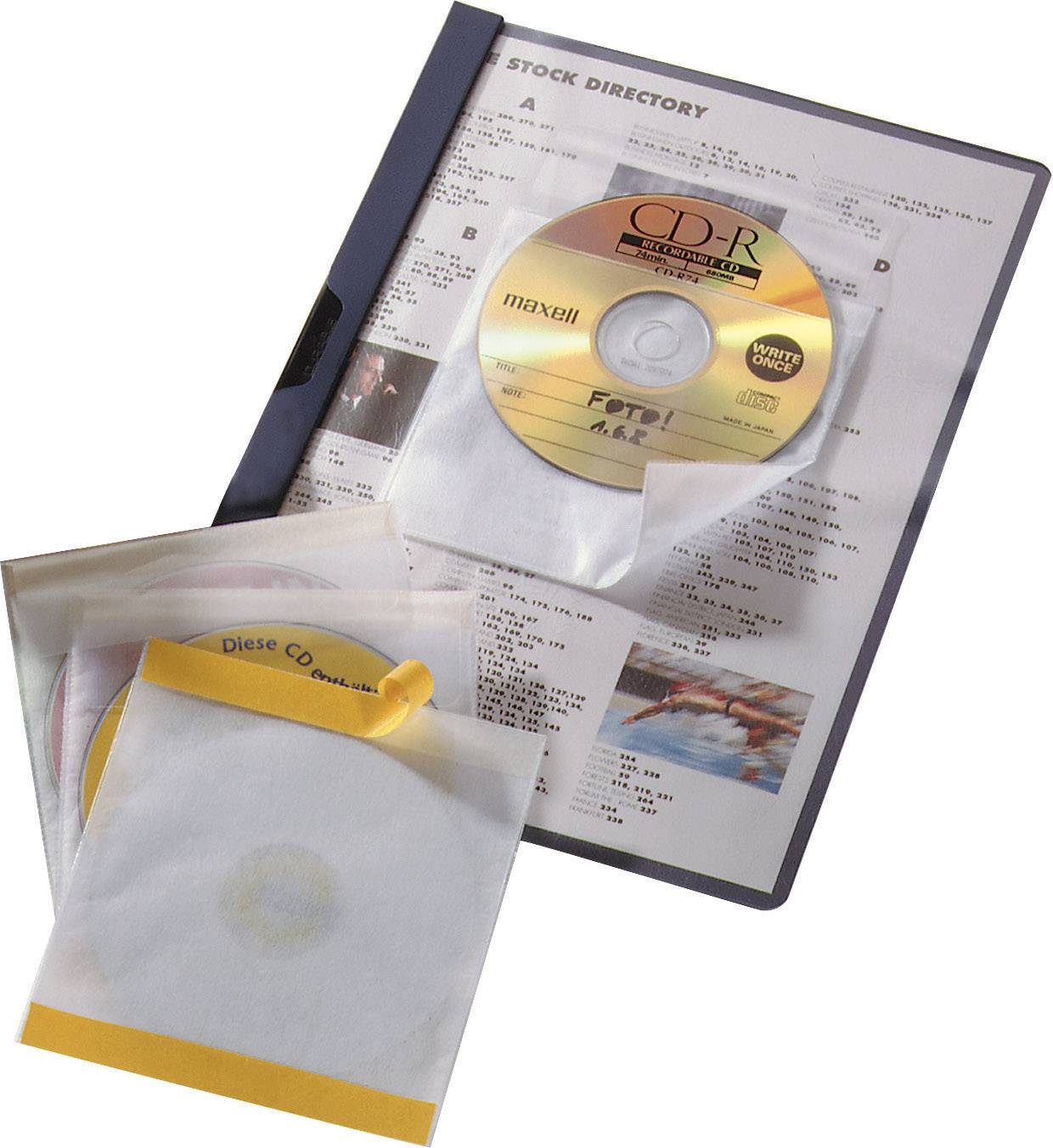 A folder with CDs; one labelled 'Photos', others in white sleeves. Background shows blurry text list.