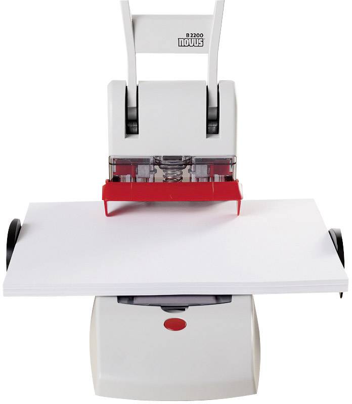 An electric hole punch is processing a thick stack of paper. It is white with red accents and has a robust construction.
