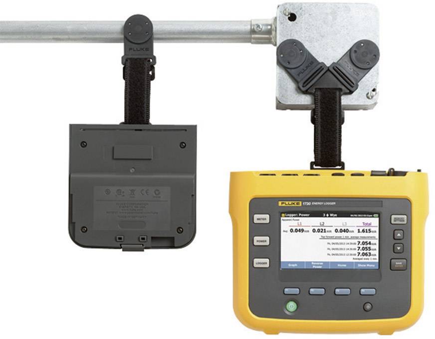 A yellow portable energy monitoring device is attached to a metallic pipeline. The screen displays measurement data.