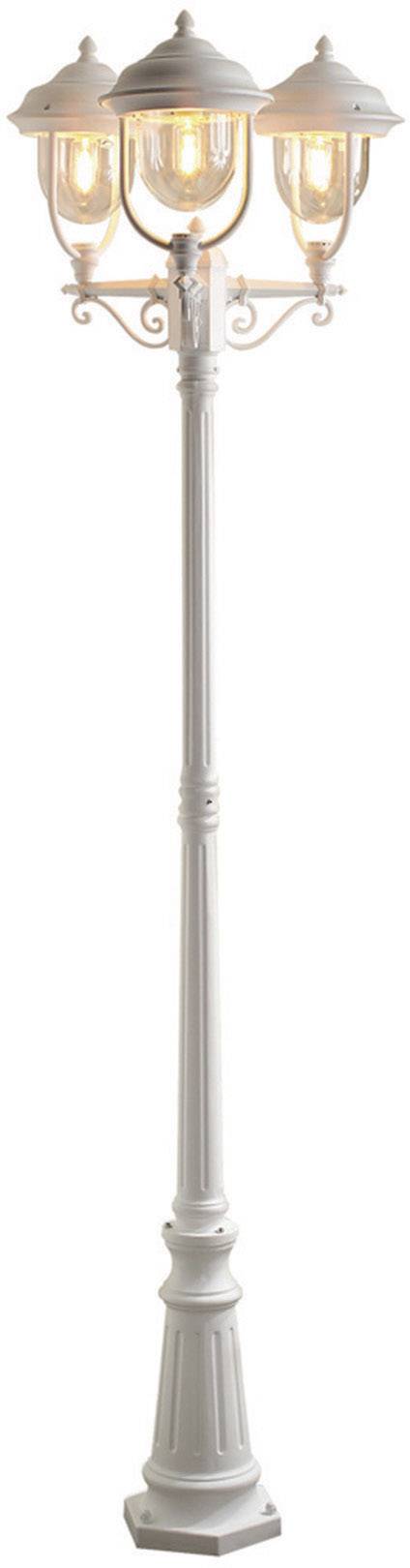 White, three-headed street lamp, illuminated, with decorative details on the lamp shades.