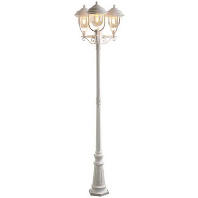 White, three-headed street lamp, illuminated, with decorative details on the lamp shades.