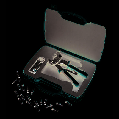 A red toolbox containing a cable crimping plier, wire stripping tool and several coaxial connectors on a white background.