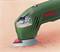 A green electric multitool with a red Bosch logo, working on a pink surface and sanding material.