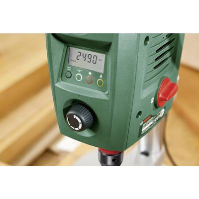 Green bench drill in close-up. The digital display shows the rotational speed '2490 rpm'. Rotary control and status indicators on the left.