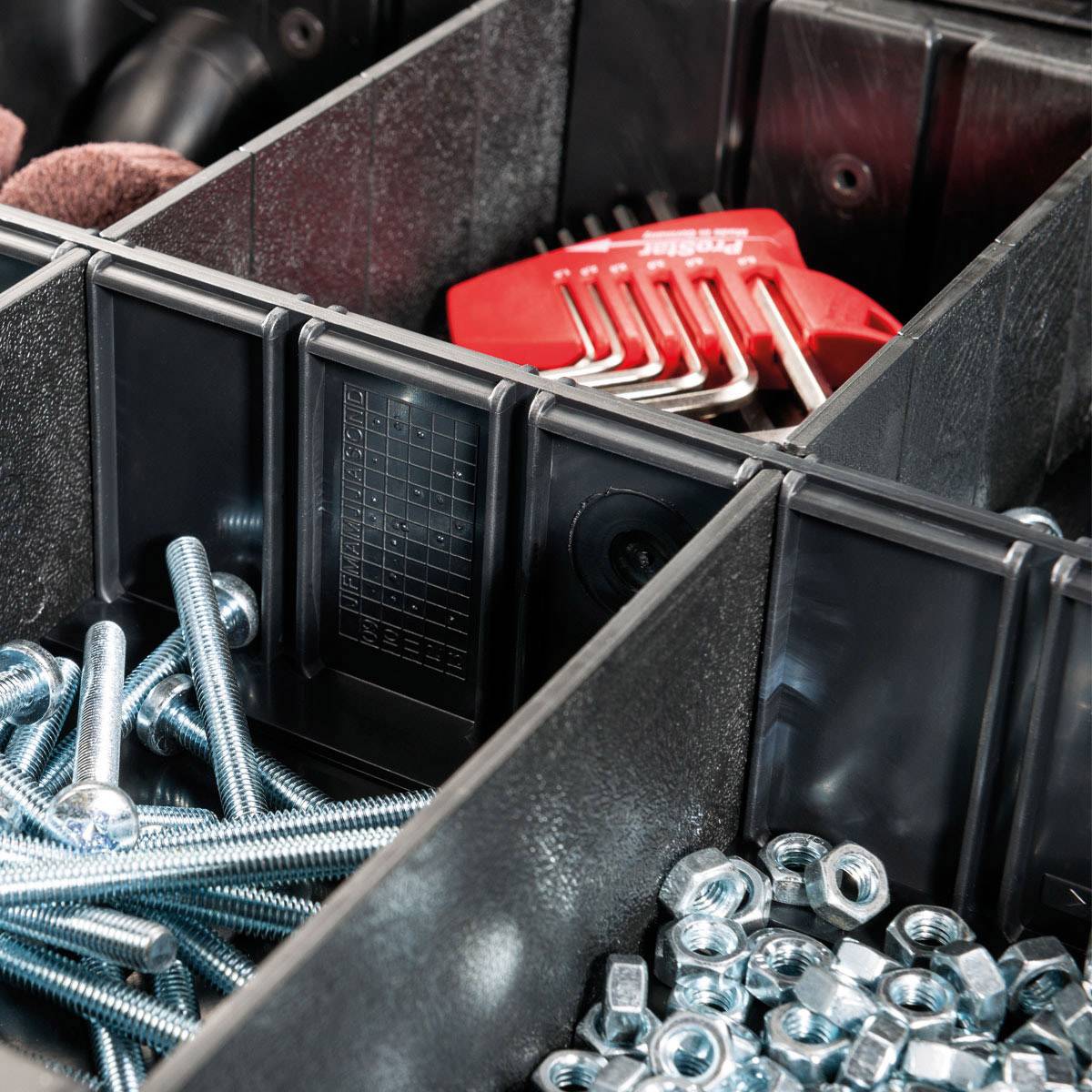 Storage tray with various metal screws and nuts. A red Allen key set is positioned in the top right corner.