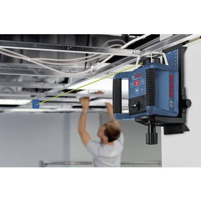 A person is adjusting a blue Bosch laser spirit level on a ceiling in a room under construction. This helps to ensure precise alignments.