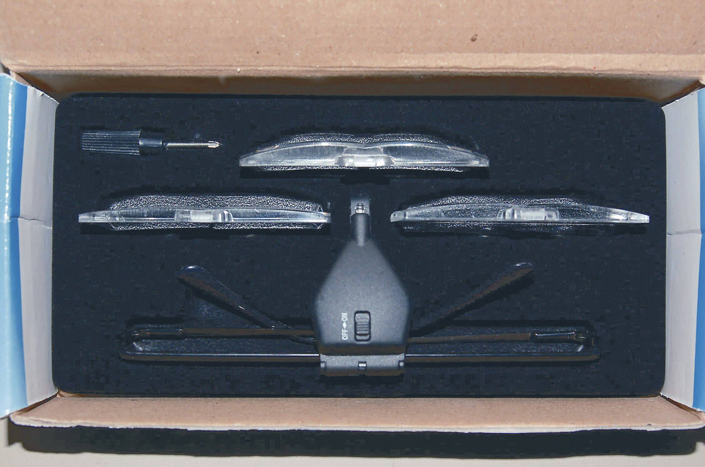 An electronic device in packaging with accessory parts, including screwdrivers and attachments, carefully cushioned inside.
