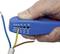 A hand is holding a blue wire stripping tool and removing the insulation from a multi-core cable to expose the wires.