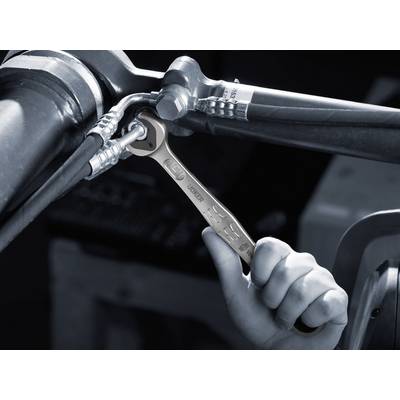 A hand is using a spanner to tighten screwed pipes.