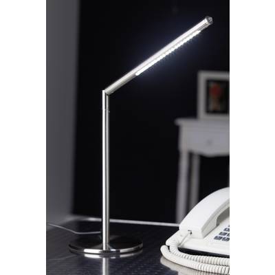 Modern metal desk lamp with glowing LED light in an office, next to a white telephone on a table.