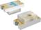 Two white SMD fuses with gold-plated terminals and a green T-print, used in electronic devices.