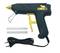 Black hot glue gun with yellow trigger, pictured with two glue sticks and power cable. Suitable for craft work.
