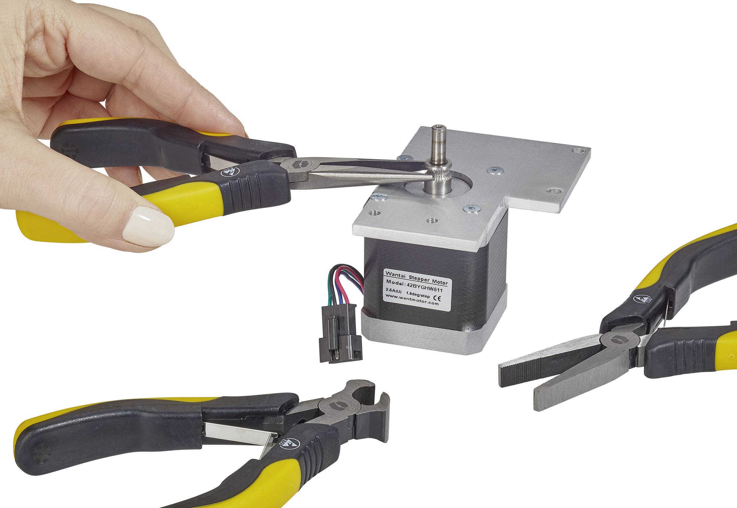 'Hand holding pliers on the motor. Additional tools and cables nearby. Focus on technical handling and repair.'