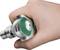A hand is holding a rotating medical device, used for examination or treatment. The device has a green rotary knob.