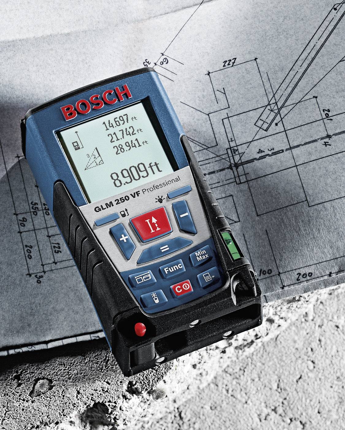 A Bosch distance meter lies on a blueprint. The device displays measurement data in metres and feet, with numbers on the display.