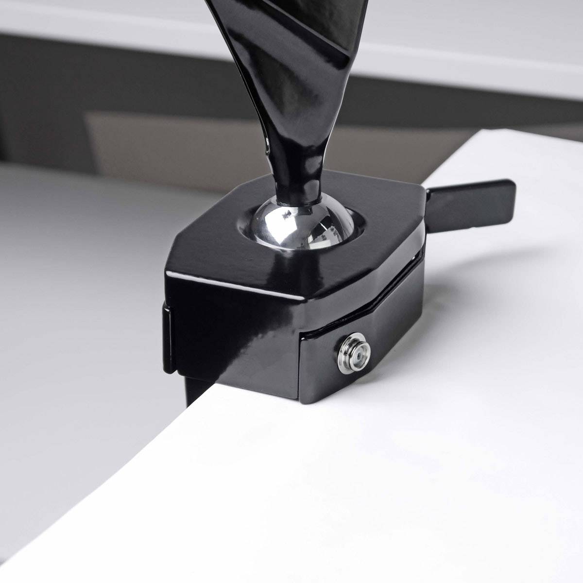 A simple black metal flag holder is fixed at the corner of a white table, visible from above.