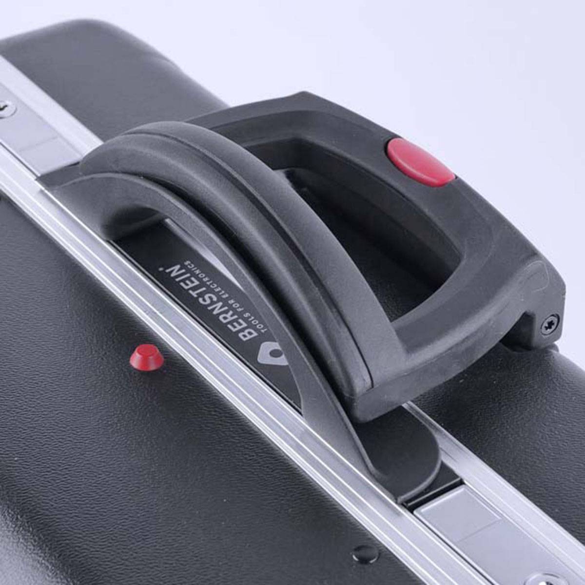 A black suitcase with a red button on the handle. The suitcase has metal reinforcements and is used for travelling.