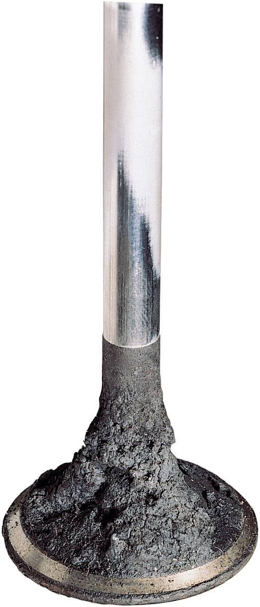 An exhaust valve of an engine with deposits indicating combustion residues signals the need for maintenance.