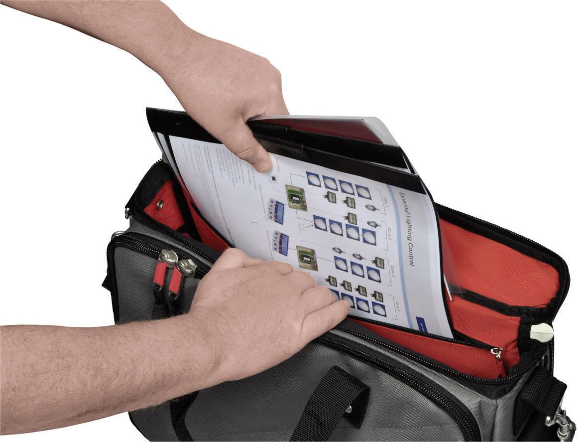 Two hands are placing a document with diagrams into an open black bag with a red lining.