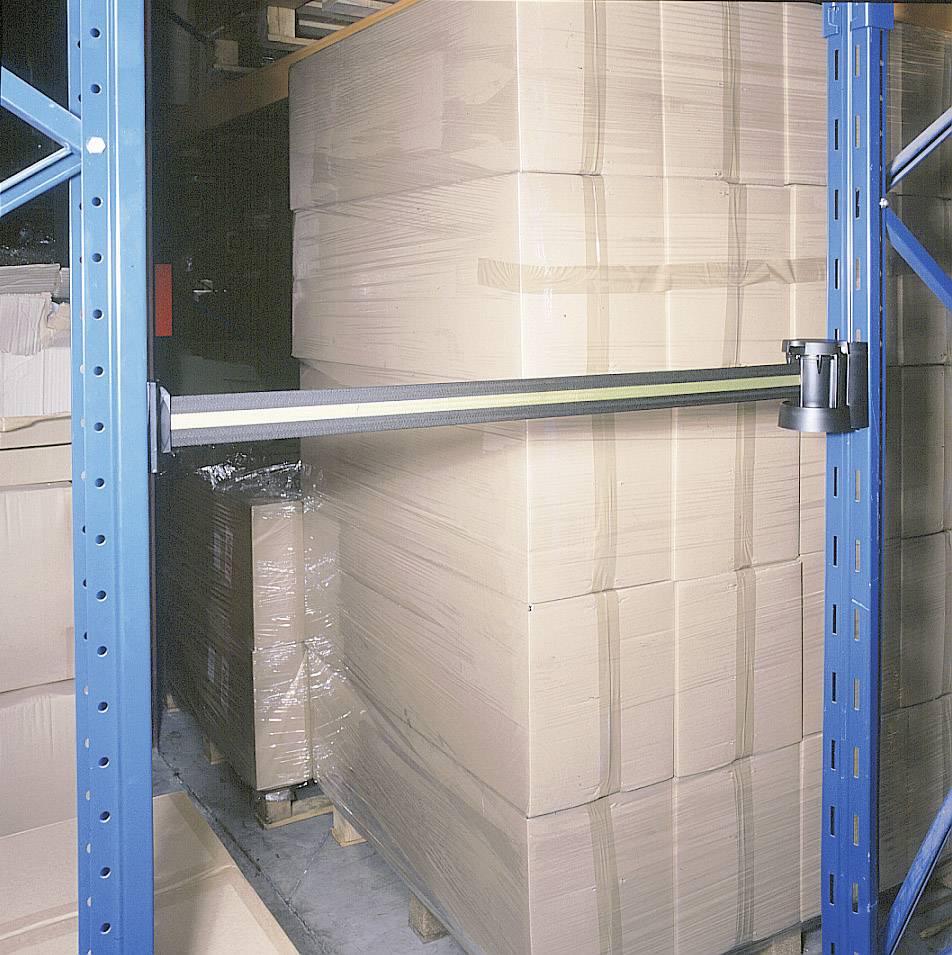 A storage rack with large cardboard boxes wrapped in plastic sheeting. A security arm is attached to secure the boxes.