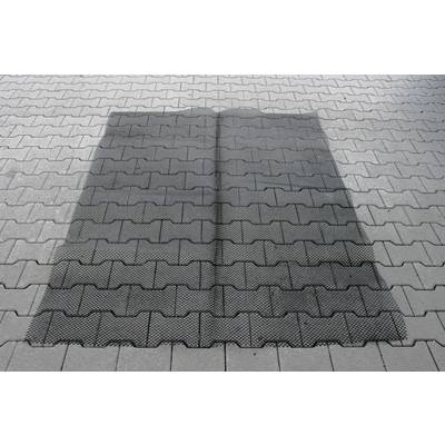 A rectangular shadow falls on a floor of grey concrete paving stones that form a regular pattern.