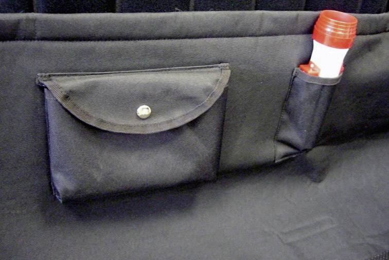 Black seat back bag with button closure and holder for a fire extinguisher.