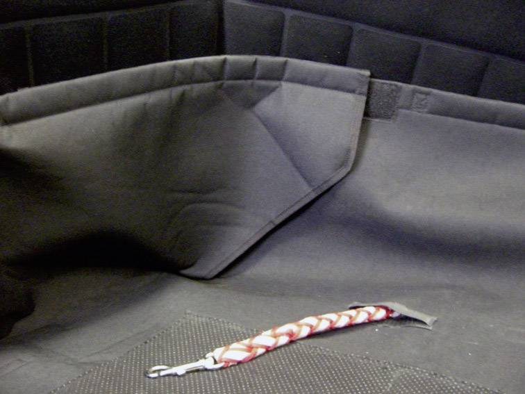 Interior of a car with black upholstery. A red and white rope loop lies on the seat.