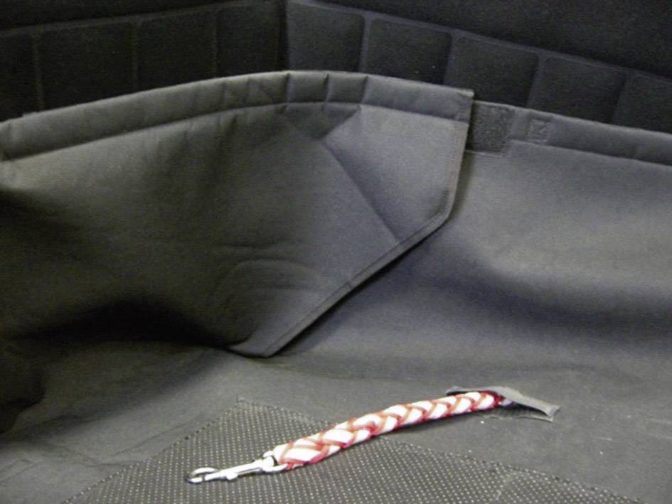 A black car boot with a red and white braided keyring is lying on the ground.