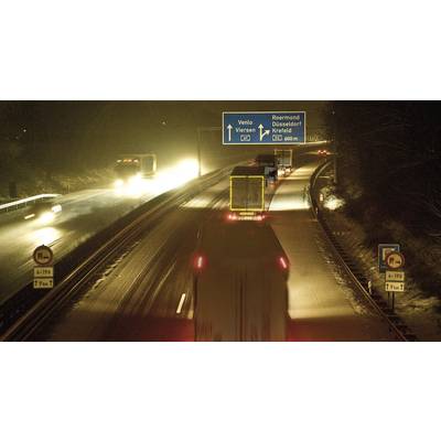 Lorries are driving at night on a motorway. A motorway sign indicates directions to Venlo, Düsseldorf and Krefeld.