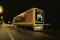 A lorry with Continental advertising drives along a lit motorway at night.
