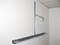 A metal bearer is mounted on a wall. Another component is fastened to it, and a hook protrudes to the side.