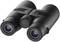 A black pair of binoculars is resting on a flat surface, with lenses facing forward.