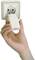 A hand is holding a white plug that is being inserted into a white socket.