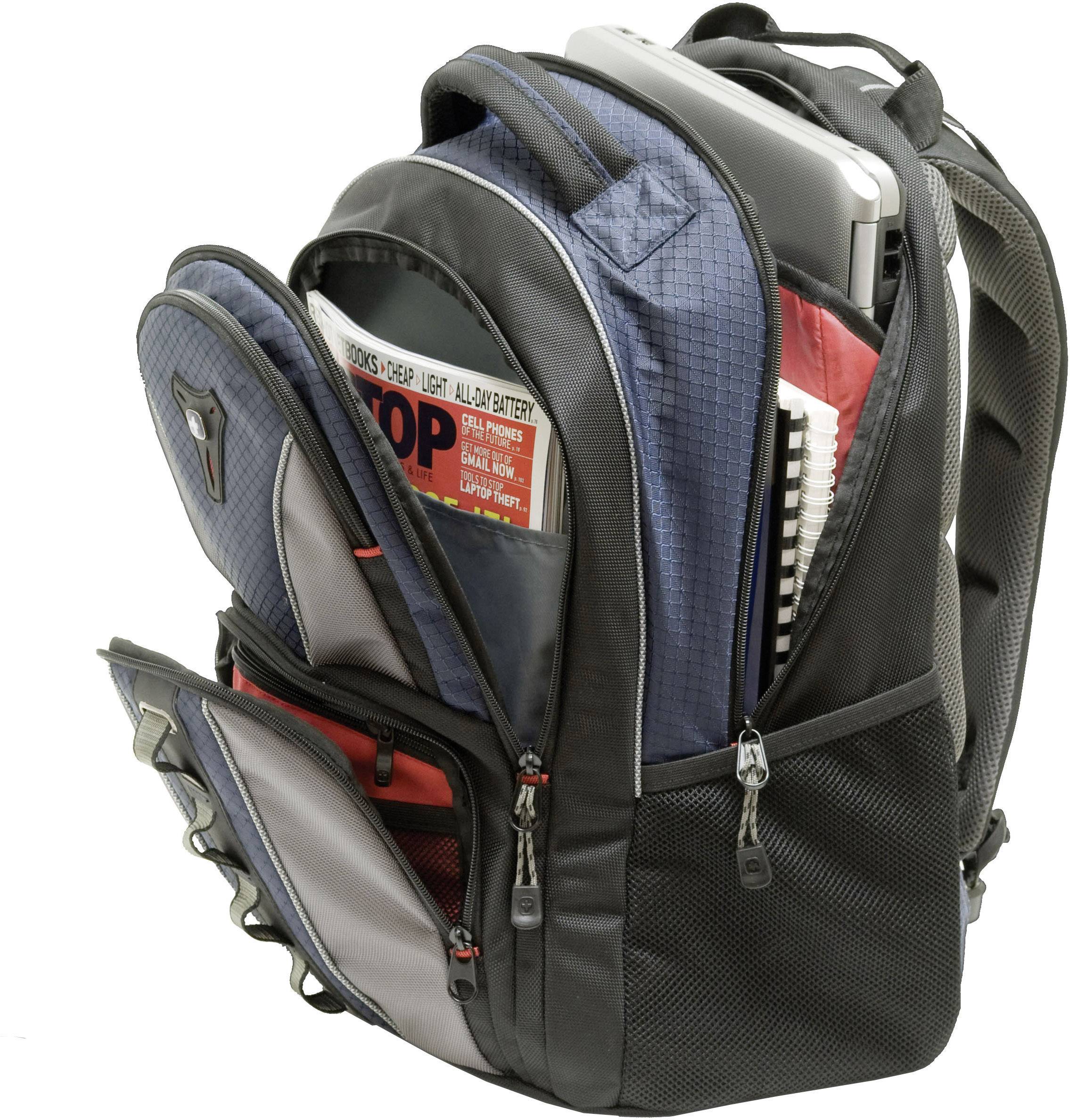An open rucksack reveals a laptop, a newspaper, and folders inside. The rucksack has multiple zipped compartments.