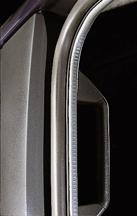 Close-up of a door handle with a metallic frame, located on the left side of the image. The background is dark.