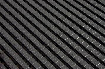 Close-up of a metal grid with uniform, intersecting struts forming a lattice structure.