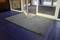 Door with grey doormat on blue tiled floor.