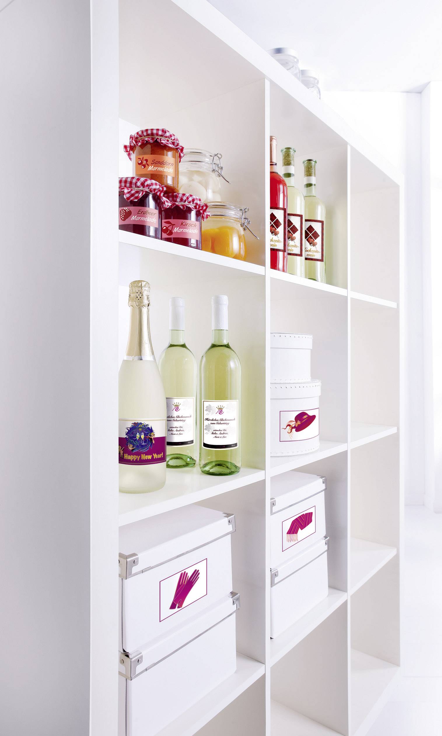 A white shelving unit with jars of jam, bottles of juice, wine, and boxes. Top shelf: jam. Middle shelf: wine. Bottom shelf: containers.