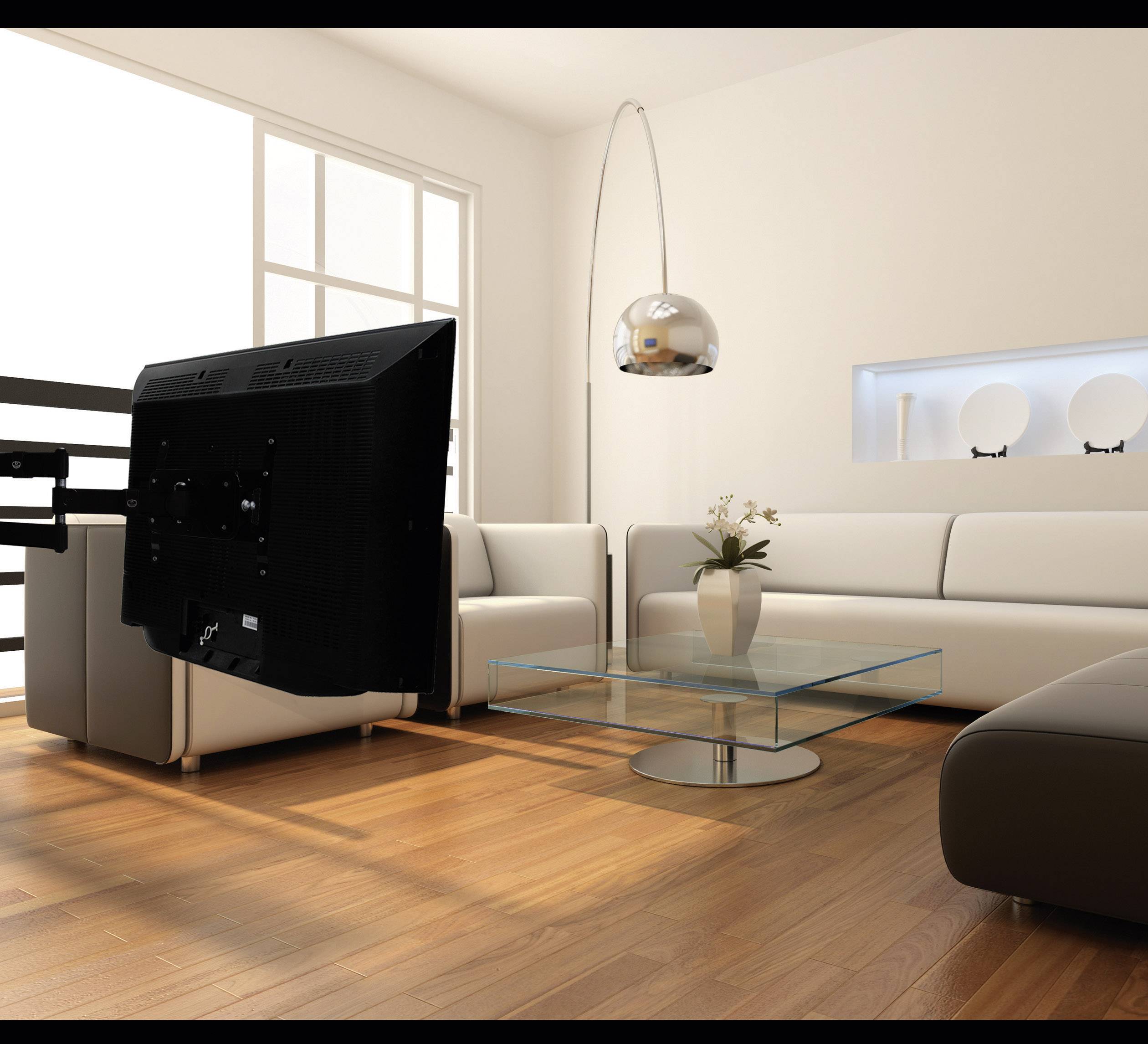Bright living room with a white sofa, glass coffee table and a wall-mounted television, wooden flooring and floor lamp.