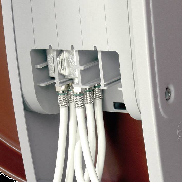 Several white cables are connected to the rear of a technical device constructed from plastic and metal.