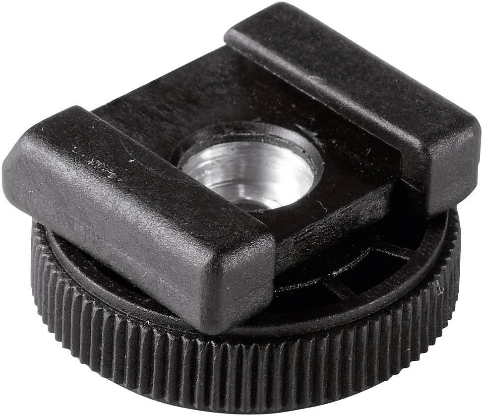 A black metal accessory shoe adapter with a ridged edge and a circular opening in the centre.