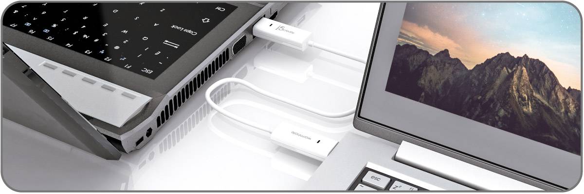 Two laptops connected by a USB cable. The first shows a keyboard, the second a mountain background screen.