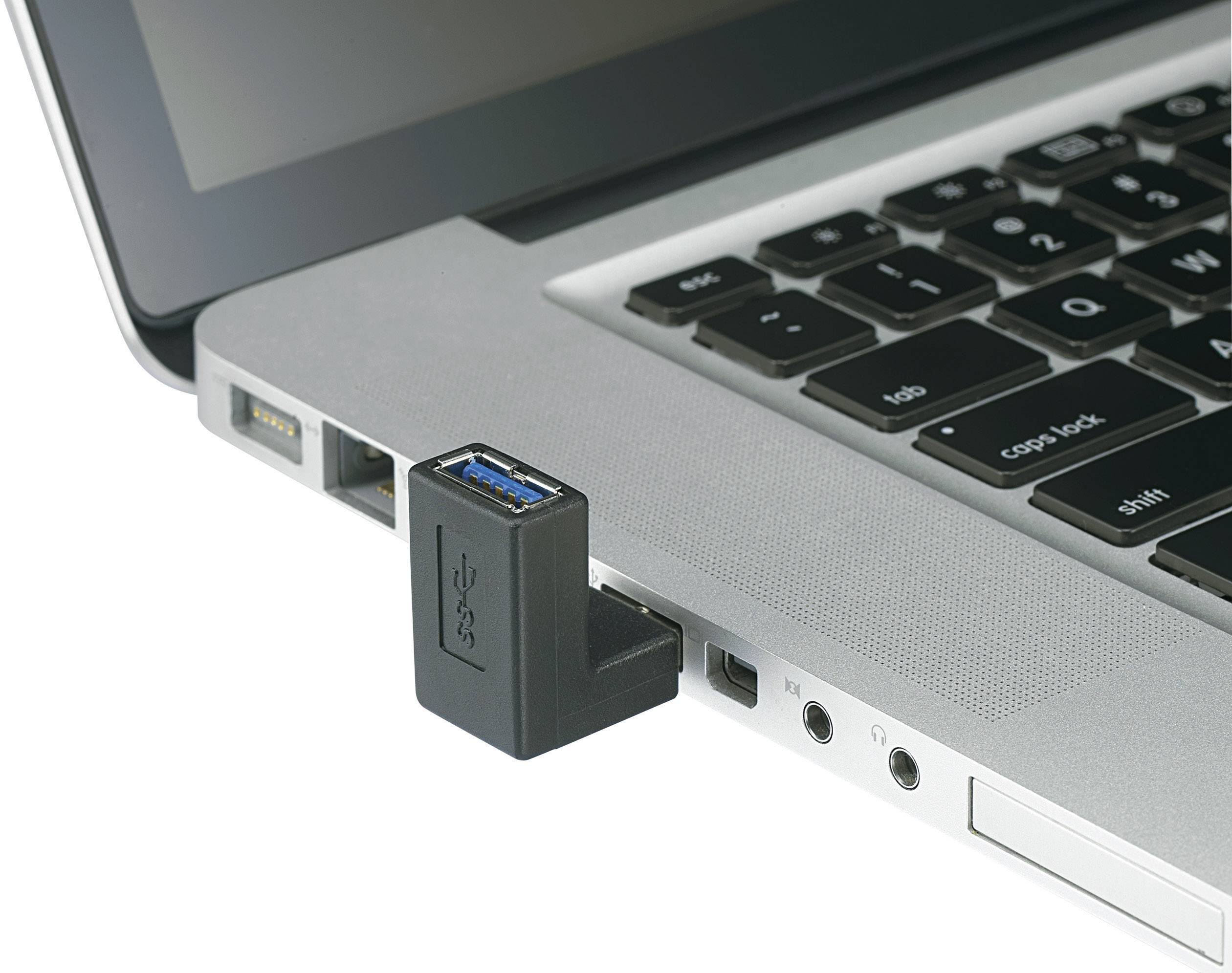 A USB stick is connected to a laptop with a silver casing, with the keyboard and several connection ports visible.