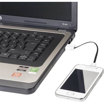 A smartphone is connected to a laptop via a USB cable. The laptop displays an open keyboard and a screen.