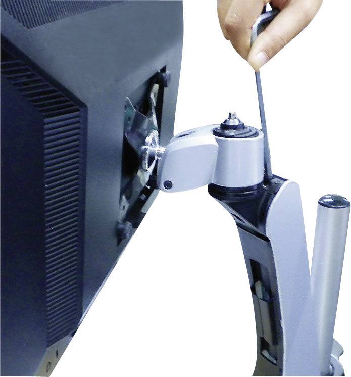 A hand is tightening a computer monitor to an adjustable monitor arm.
