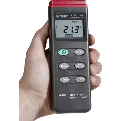 Une main tient un thermomètre électronique de Voltcraft. L'affichage indique 21,3°C. Touches pour Hold, Minuterie, Moyenne, Max, Min et changement d'unité.