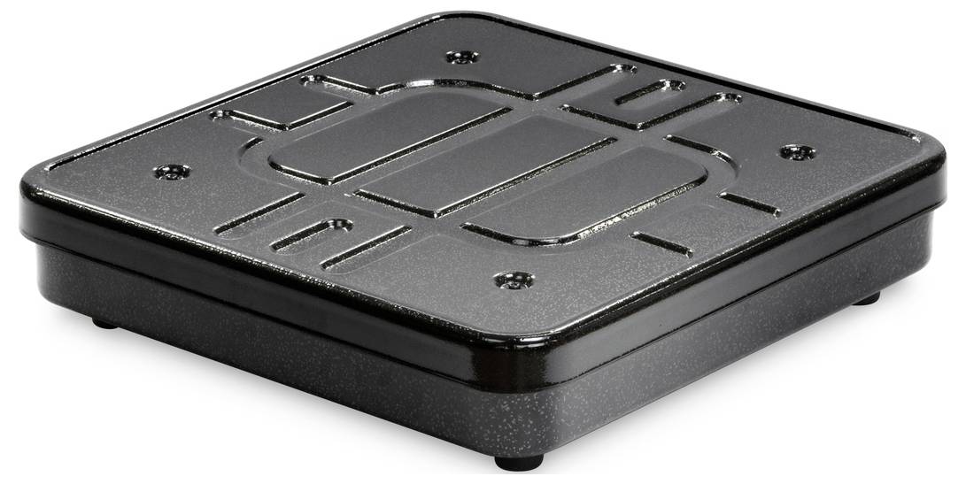 Un objet noir, carré, doté d'une surface structurée et de bords arrondis. Il repose légèrement surélevé sur de petits pieds.