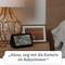 Un appareil vocal sur une table de chevet montre un bébé dans un parc. En dessous, il est écrit : « Alexa, montre-moi la caméra de la chambre de bébé. »