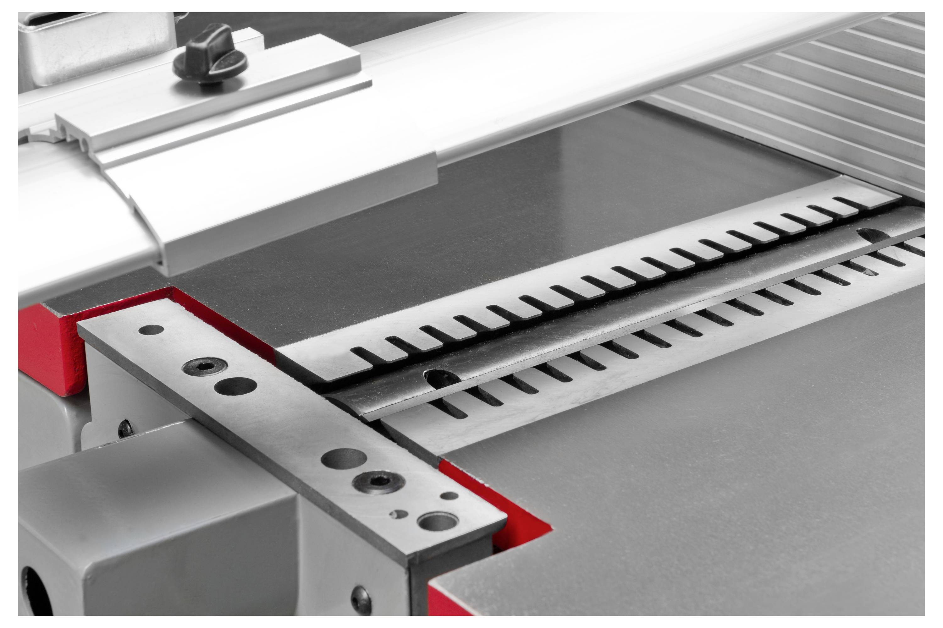 Gros plan d'une machine de précision avec une surface métallique et une échelle, utilisée pour des mesures ou des traitements précis.