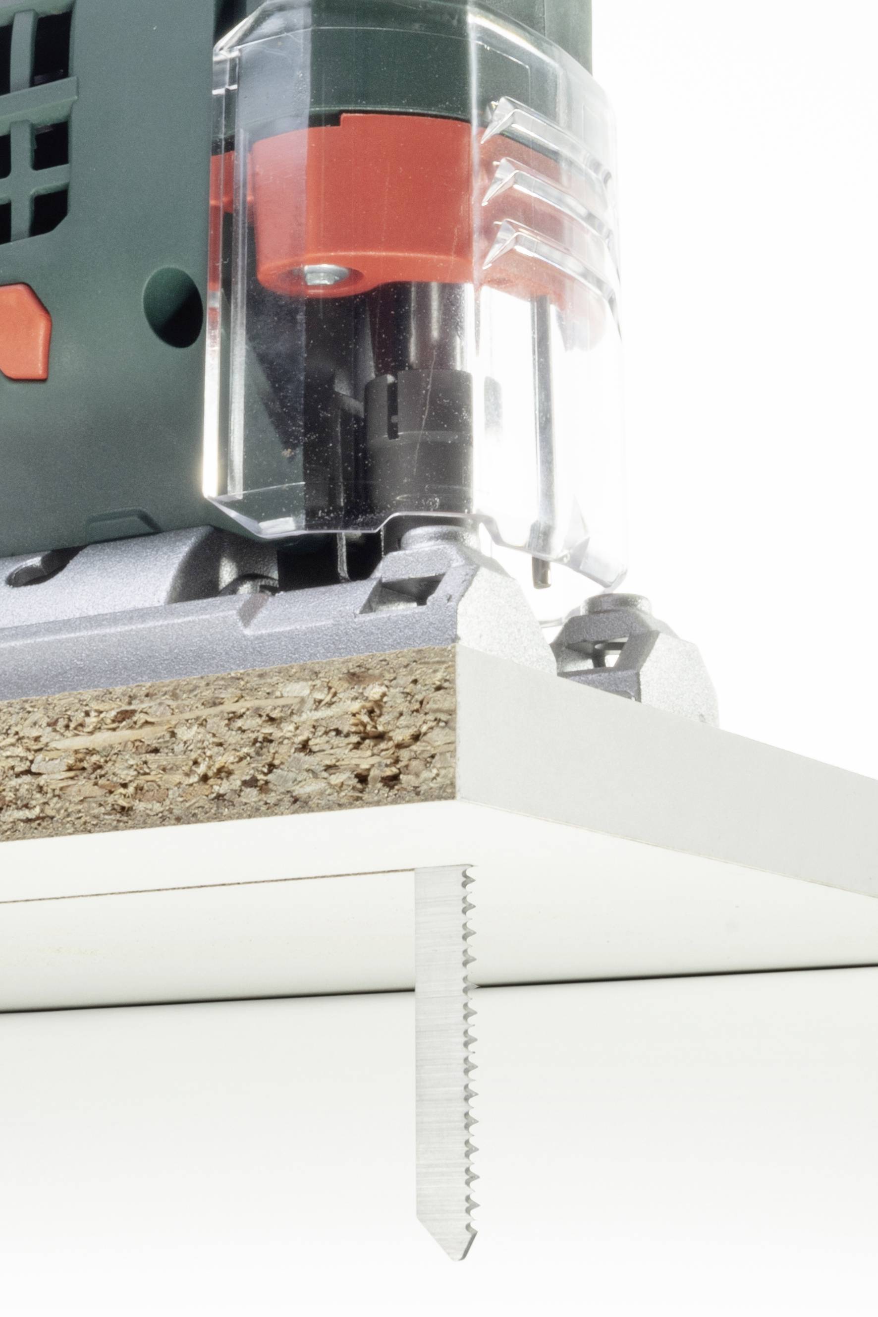 Scie sauteuse coupe précisément à travers une planche de bois, gros plan sur la lame de scie et la surface de coupe, accent mis sur l'utilisation de l'outil.